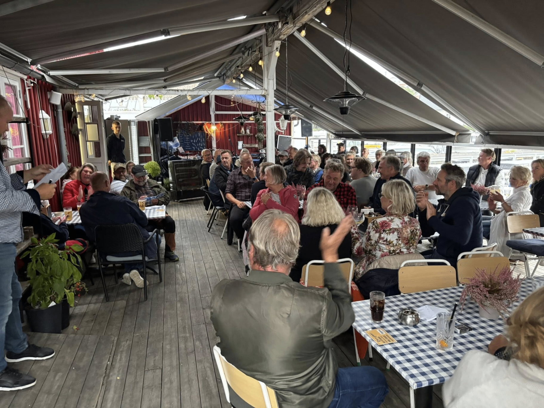Fornøyde gjester klapper under arrangement på Sjøbua – god stemning og fellesskap ved bryggekanten i Sponvika nær Halden