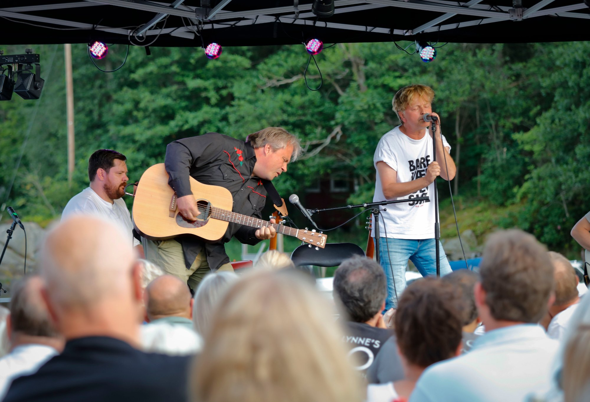 Live musikk på Sjøbua i Sponvika – artist på scenen med gitar skaper festlig stemning ved Ringdalsfjorden nær Halden